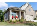 Beautiful home featuring a cozy front porch, manicured lawn, and brick facade at 330 Carriage Glen Ln, Woodstock, GA 30188