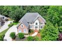 Elegant brick home with a manicured lawn, mature trees, and a private driveway in a serene setting at 12130 Helleri Holw, Alpharetta, GA 30005