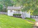 Lovely home featuring a well-kept lawn, white siding, and a charming front porch with staircase access at 394 Thornbrooke Dr, Hiram, GA 30141