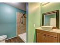 Bathroom showcasing a walk-in shower, a vanity with a vessel sink, a modern faucet, and wood look tile floor at 165 Country Mill Ln, Stockbridge, GA 30281