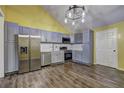 Modern kitchen features stainless steel appliances, stylish grey cabinetry, and an adjacent dining area at 165 Country Mill Ln, Stockbridge, GA 30281