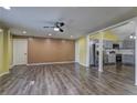 Bright living room featuring wood floors, neutral walls, ceiling fan, and an open layout that flows into the kitchen at 165 Country Mill Ln, Stockbridge, GA 30281