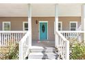 Inviting front porch with a bright blue door and white railings, creating a welcoming entrance at 6744 Rockbridge Rd, Stone Mountain, GA 30087