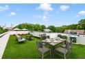 Inviting rooftop terrace featuring a dining area, lounge seating, artificial grass, and distant city views at 167 Sampson Ne St, Atlanta, GA 30312