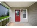 Cozy front porch featuring a red door and a window for natural light, perfect for enjoying the outdoors at 2732 Dahlonega Trl, Austell, GA 30106