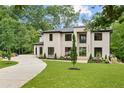 Elegant modern home with a painted brick facade, manicured lawn, and a circular driveway at 4125 Ashwoody Ne Trl, Brookhaven, GA 30319