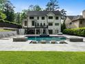 A private backyard oasis showcasing a pristine pool with integrated lounge areas and lush green surroundings at 4225 Wieuca Ne Rd, Atlanta, GA 30342