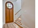 Bright entryway features hardwood floors, a wooden door with glass, and stairs with built-in lighting at 2179 William Way, Atlanta, GA 30345