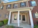 Attractive brick townhome featuring a covered entryway with a dark front door and white trim at 2555 Flat Shoals Rd # 3405, Atlanta, GA 30349