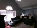 Inviting living room featuring vaulted ceilings, an oversized sectional sofa, and bright natural light from large windows at 49 Brinkley Ct, Dallas, GA 30157
