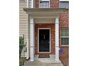 Inviting entryway featuring a covered porch with classic columns and a black front door at 440 Berckman Nw Dr, Lilburn, GA 30047