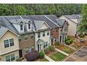 Aerial view of townhomes with well-manicured lawns and mature trees offering a serene living environment at 440 Berckman Nw Dr, Lilburn, GA 30047