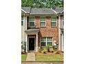 Brick townhome with a covered entrance, well-kept lawn, and classic architectural details at 440 Berckman Nw Dr, Lilburn, GA 30047