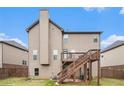 View of the rear exterior showcasing a wooden deck and a spacious, fenced backyard at 949 Nevis Way, Mcdonough, GA 30253
