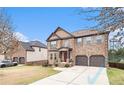 Charming brick home featuring a two-car garage, manicured lawn, and inviting curb appeal at 949 Nevis Way, Mcdonough, GA 30253