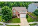 Aerial view of a well-maintained two-story home with a lush green lawn and mature trees at 1727 Shire Village Dr, Sugar Hill, GA 30518