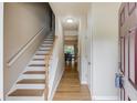 Inviting entryway featuring hardwood floors, staircase, and natural light at 1727 Shire Village Dr, Sugar Hill, GA 30518