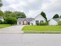 Classic home featuring a green lawn, vinyl siding, brick facade, and a driveway leading to an attached garage at 2647 Midler Ct, Buford, GA 30519