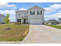 Two-story home with a large garage, light gray siding and black shutters at 600 Tudor St, Kingston, GA 30145