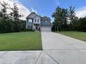 Charming two-story home with blue siding, well-manicured lawn, and attached two-car garage at 17 Kola Ln, Rydal, GA 30171