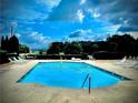 Beautiful community swimming pool surrounded by lounge chairs and lush trees with a mountain view at 17 Kola Ln, Rydal, GA 30171