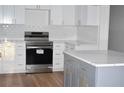 Modern kitchen with white cabinets, quartz countertops, stainless steel appliances, and an island at 2502 Tupelo Se St, Atlanta, GA 30317