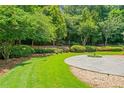 Serene backyard with a stone patio and lush landscaping, perfect for outdoor relaxation at 425 Greenmont Walk Ct, Alpharetta, GA 30009