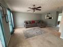 Cozy living room featuring neutral walls, plush sofa, a ceiling fan, and large windows at 6231 Redan Overlook, Lithonia, GA 30058
