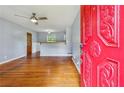 Inviting living room features hardwood floors, ceiling fan, and view into updated kitchen at 4653 Ridgewood Dr, Forest Park, GA 30297