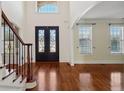 Bright, open foyer features gleaming hardwood floors, black wrought iron railings, and double doors at 5615 Toccoa Dr, Douglasville, GA 30135