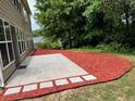 Beautifully landscaped backyard with mulch, concrete patio, and mature trees at 5669 Avonley Creek Dr, Sugar Hill, GA 30518