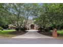 Traditional brick home with mature trees, landscaped grounds, and an elegant entrance at 7660 Treeridge Ct, Atlanta, GA 30350