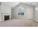 Bright living room with vaulted ceiling, fireplace, carpet flooring, and a large window at 2721 Grapevine Cir # 1701, Cumming, GA 30041