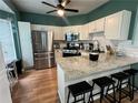 Modern kitchen featuring stainless steel appliances, granite countertops, and a breakfast bar with seating at 4336 Thorngate Ln, Acworth, GA 30101