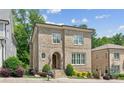 Charming two-story brick home with arched entry, manicured landscaping, and bright windows at 5971 Brundage Lane, Norcross, GA 30071