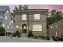 Charming two-story brick home with arched entry, manicured landscaping, and bright windows at dusk at 5971 Brundage Lane, Norcross, GA 30071