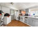 Kitchen features grey cabinetry, appliances, a washing machine, and laminate flooring at 1151 Sheppard Pl, Stone Mountain, GA 30083