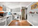 Kitchen features grey cabinetry, appliances, a washing machine, and laminate flooring at 1151 Sheppard Pl, Stone Mountain, GA 30083