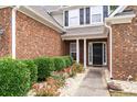 Close-up of the front entrance with brick facade and landscaped garden at 320 Roland Manor Dr, Dacula, GA 30019