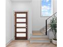 Modern entryway featuring a wood door with glass panels, stairs, and natural light at 42 Riverdale St, Canton, GA 30114
