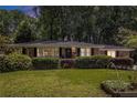Charming brick home with manicured lawn and mature trees provides great curb appeal at dusk at 1747 Remington Rd, Atlanta, GA 30341