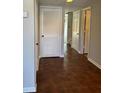Hallway with wood-look tile flooring, neutral paint and various doorways to rooms in the home at 731 Hanover Se Ln, Marietta, GA 30067