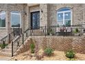 Inviting front porch with elegant iron railings, seating, landscaping, and a decorative front door, perfect for relaxing outdoors at 2548 Westchester Se Way, Conyers, GA 30013