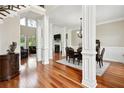 Elegant living room featuring hardwood floors, decorative columns, a fireplace, and large windows for ample natural light at 2548 Westchester Se Way, Conyers, GA 30013