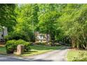 Beautiful two-story home nestled among lush greenery with a long driveway at 815 Marshview Close, Roswell, GA 30076