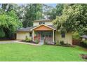 Charming two-story home featuring a lush lawn, covered porch, and attached garage at 1653 Terry Mill Se Rd, Atlanta, GA 30316