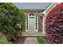 Inviting front entrance with decorative stone accents, a light green door, and colorful landscaping at 4710 Vineyard Se Ct, Smyrna, GA 30082