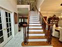 Spacious foyer with elegant staircase, marble floors, and view of the living room at 703 Overlook Point, Woodstock, GA 30189