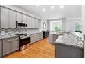Open kitchen with gray cabinetry, granite counters, stainless steel appliances, and a breakfast area at 1286 Creekside Se Ter, Smyrna, GA 30082