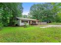 Exterior view of a single-story house with a covered porch and a spacious grassy front yard at 20 Cheryl Ter, Covington, GA 30016